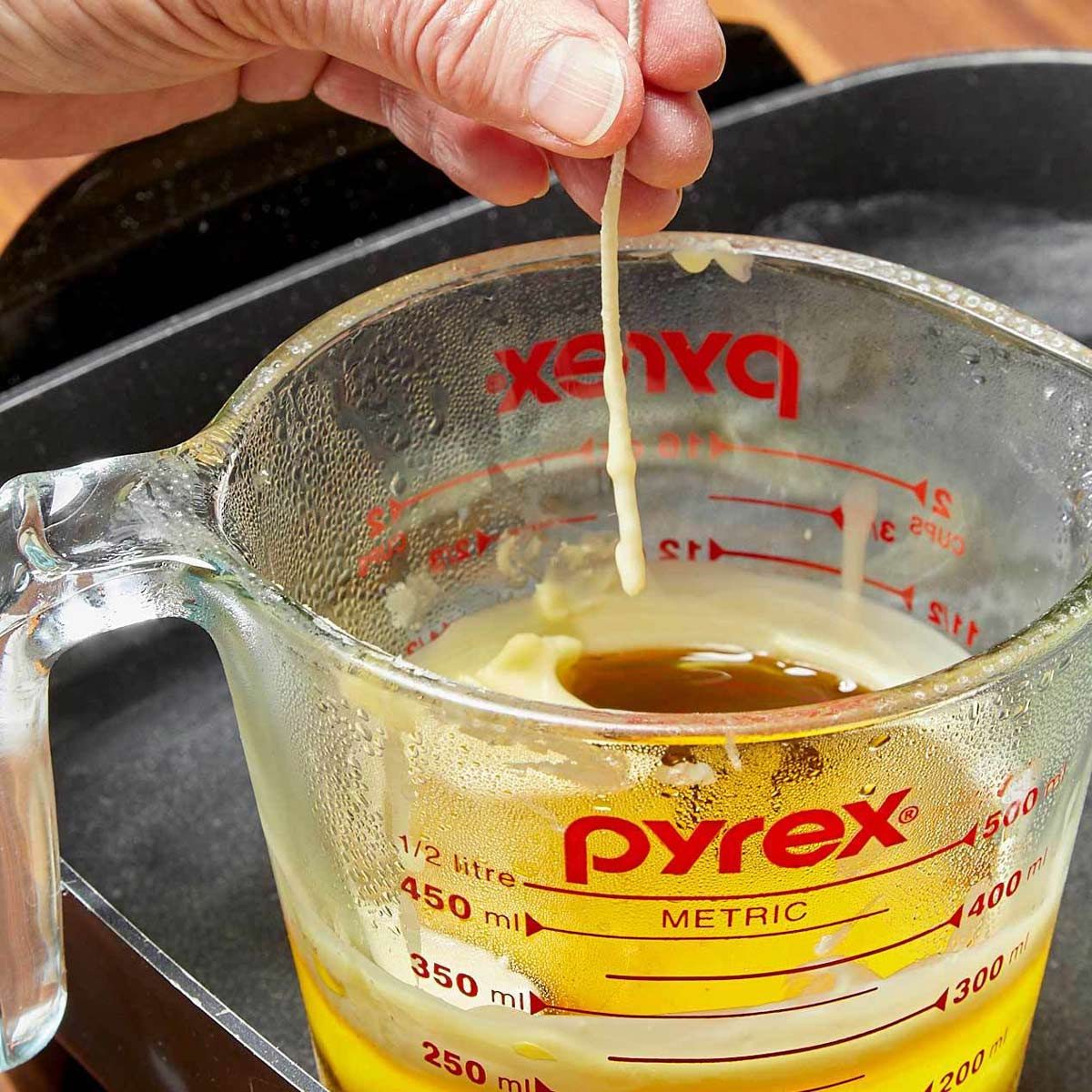 Dip the wicks for your DIY beeswax candles